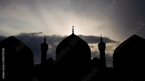 Qom: Shrine of Fatima Masumeh, Time Lapse at Sunrise with Fast Clouds and Dark Silhouette of Domes and Minarets photo