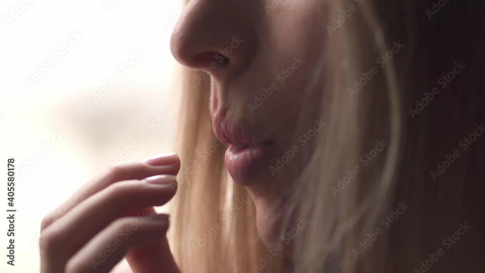 Woman eating juicy slice of pomelo, close up portrait