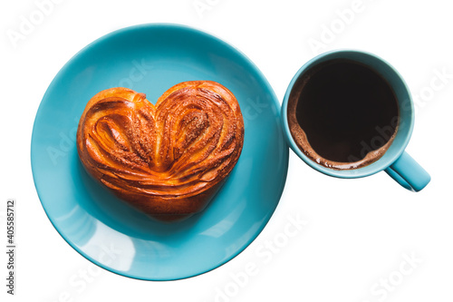 Heart-shaped pastry on the blue plate and the cup of coffee. Isolataed on a white background. photo