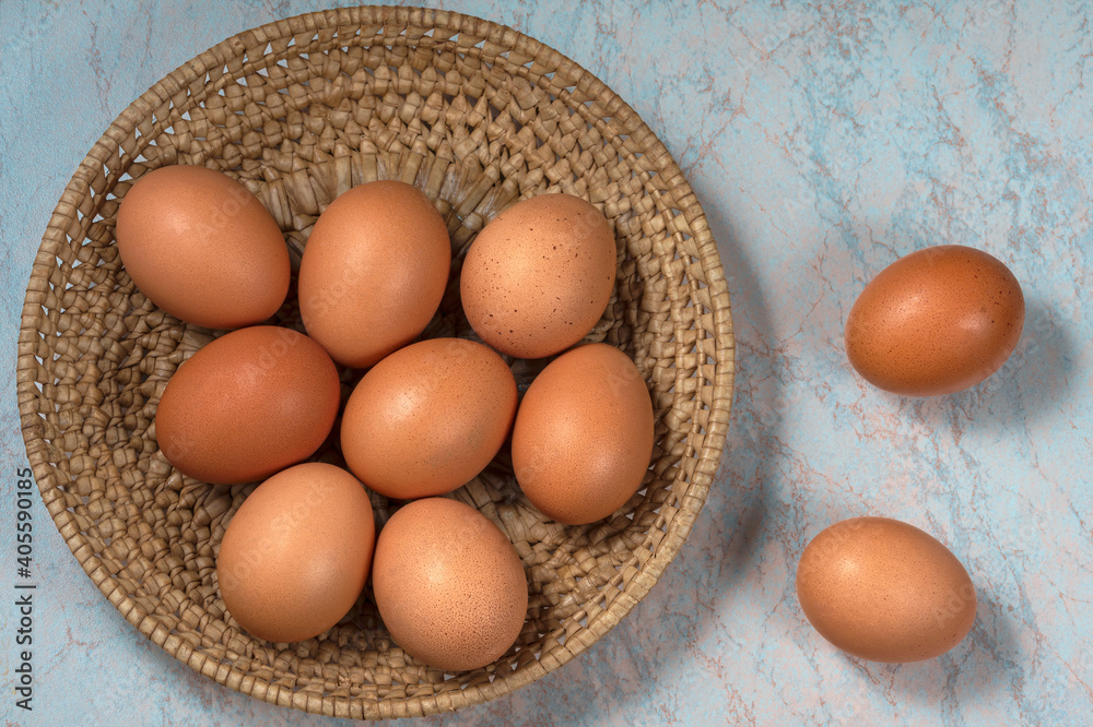 several fresh chicken eggs in a straw basket on a wooden background. Healthy eating concept. several fresh chicken eggs in a straw basket on a wooden background. Healthy eating concept.