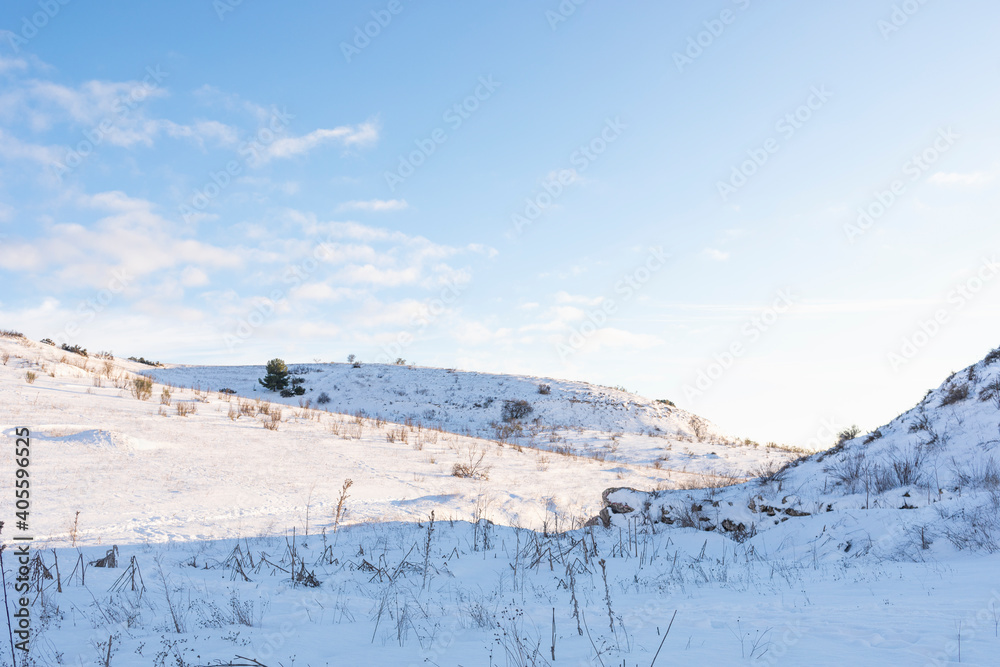 Fototapeta premium Hilly snowy landscape with clear blue sky