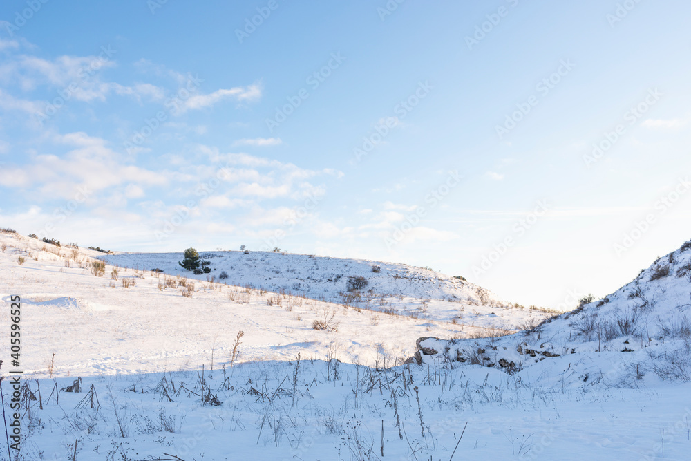Hilly snowy landscape with clear blue sky