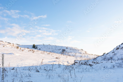 Hilly snowy landscape with clear blue sky