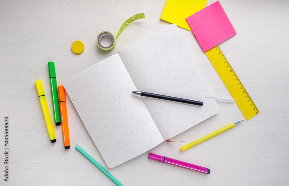 Open blank bullet journal planner with dotted pages with a pen, markers ...