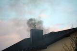 Dark smoke from a chimney from a single-family house