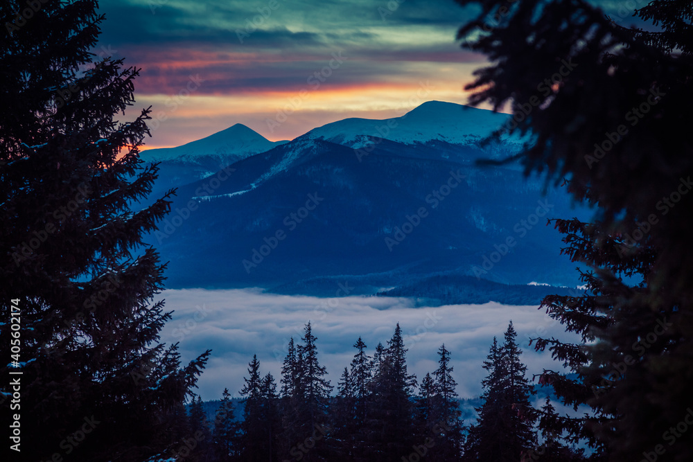 Beautiful dawn in the winter snow-covered mountains and amazingly beautiful clouds