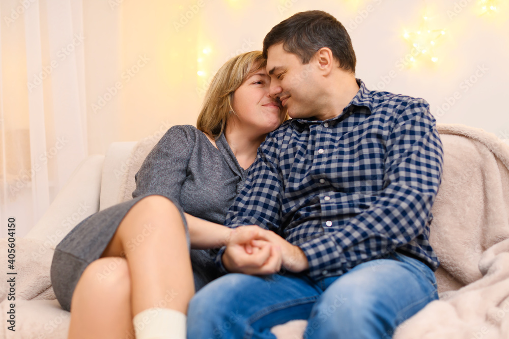 portrait of adult couple sitting on a sofa at home portrait of adult couple sitting on a sofa at home