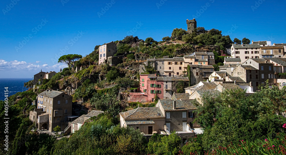 The village Nonza, located both the side of a cliff, Cap Corse, Corsica, France. Tower (Tour Paoline) on top of the cliff. 