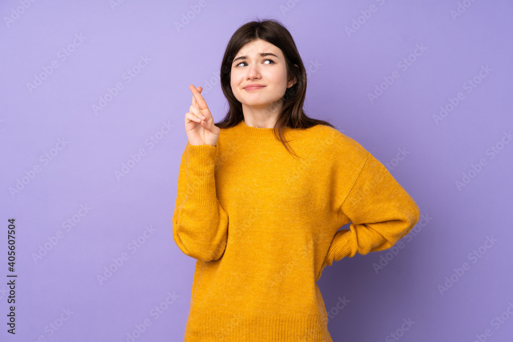 Young Ukrainian teenager girl over isolated purple background with fingers crossing and wishing the best Young Ukrainian teenager girl over isolated purple background with fingers crossing and wishing the best