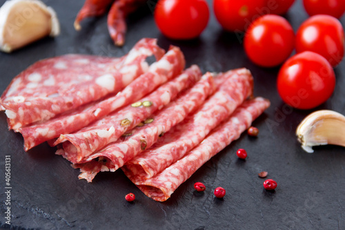 Salami smoked sausage slices with sliced sausage, and tomatoes. Selective focus.