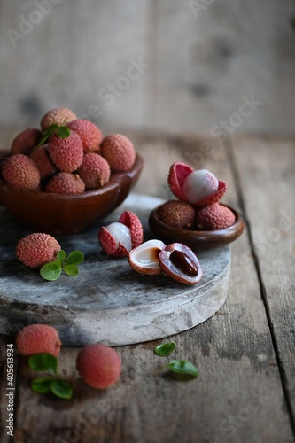 Fresh red lychee fruits. Fresh organic lychee fruit on a rustic wooden background.