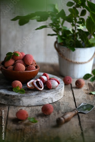 Fototapeta Naklejka Na Ścianę i Meble -  Fresh red lychee fruits.  Fresh organic lychee fruit on a rustic wooden background.