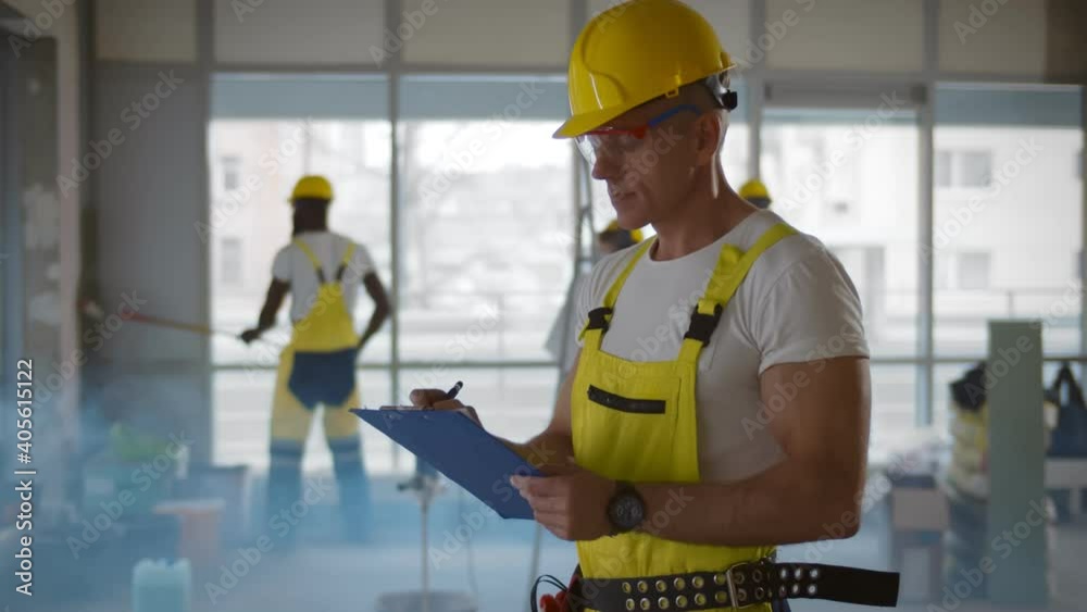 Senior foreman checking and inspecting with clipboard at construction site