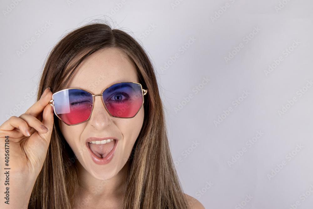 An attractive woman with long hair wearing summer sun glasses looking happy An attractive woman with long hair wearing summer sun glasses looking happy