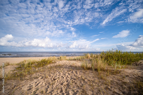 the baltic sea beach is so romantically beautiful and calm, small waves and sun shining in the clouds