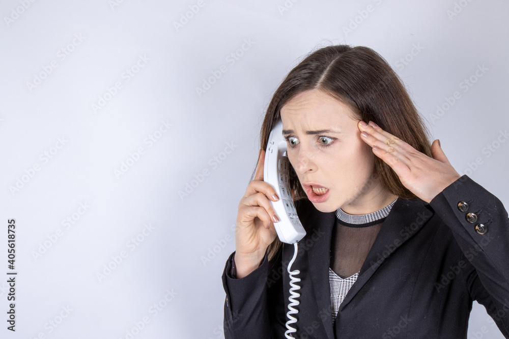 An attractive business woman with long hair looking upset and angry on the telephone An attractive business woman with long hair looking upset and angry on the telephone