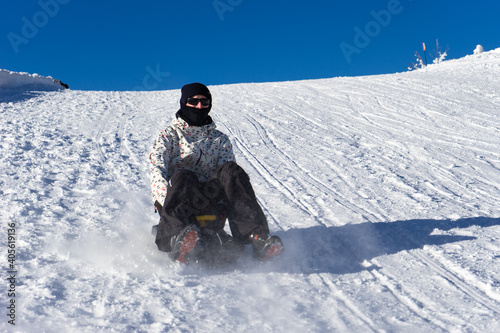 Boy sledging at Markstein ski resort on a cold sunny day.