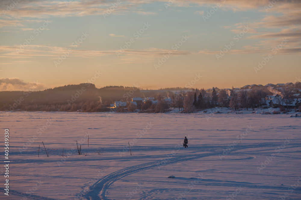 People walk on ice across the river. Winter and people in the morning.