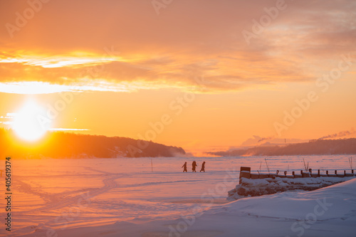 People walk on ice across the river. Winter and people in the morning. © vov8000