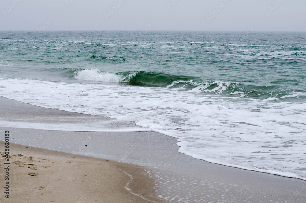 Stormy sea. Waves roll onto the shore. Deserted beach.