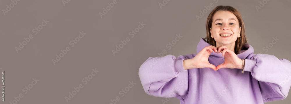 Woman show heart hands isolated on gray background Woman show heart hands isolated on gray background