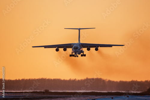 Military transport plane comes in to land on the runway of the airfield photo