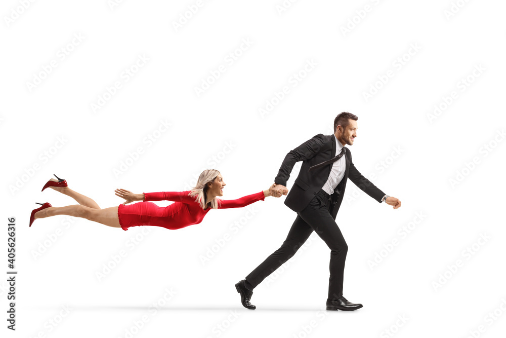 Businessman running and pulling a flying woman in a red dress