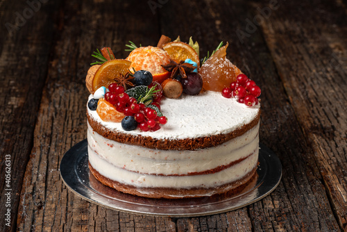 Delicious fruit cake made from delicious ingredients and cream, on a wooden textured background. Close-up.