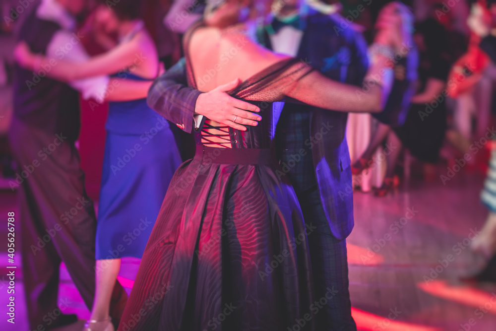 Couples dancing traditional latin argentinian dance milonga in the ballroom, tango salsa bachata kizomba lesson in the red lights, dance festival - obrazy, fototapety, plakaty 