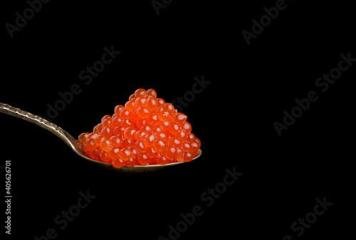fresh grainy red chum salmon caviar in a metal spoon, delicious and healthy food