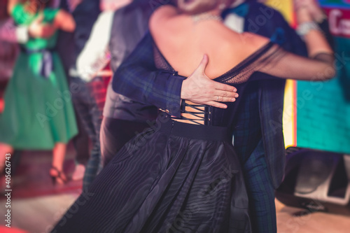 Couples dancing traditional latin argentinian dance milonga in the ballroom, tango salsa bachata kizomba lesson in the red lights, dance festival © tsuguliev