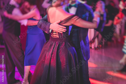 Couples dancing traditional latin argentinian dance milonga in the ballroom, tango salsa bachata kizomba lesson in the red lights, dance festival photo