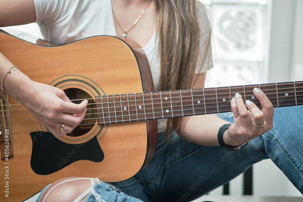 Fototapeta premium girl's hands playing an acoustic guitar