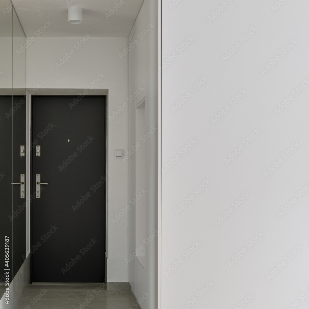 Narrow white corridor with mirror