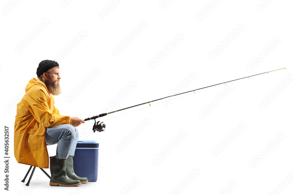 Profile shot of a bearded fisherman catching with a fishing pole seated on a chair