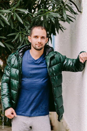 man wearing blue t-shirt mockup and jacket outdoors. Male in blank blue t-shirt v collar, front view outdoors. Design men t shirt template and mock-up for print 