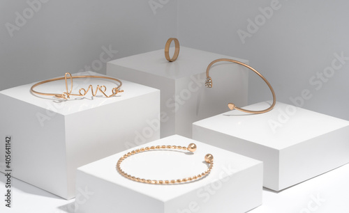 Photographie Love word shape Golden bracelets collection on white geometric background
