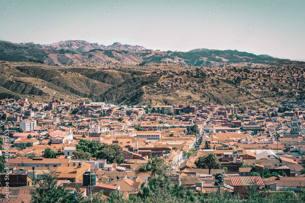 Panoramic view of city of Sucre in Bolivia, with colonial style buildings and mountains in the background.