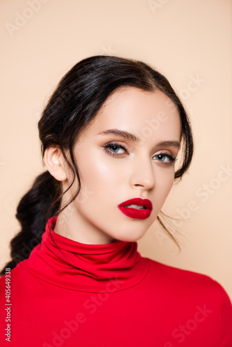 brunette woman with red lips looking at camera isolated on pink