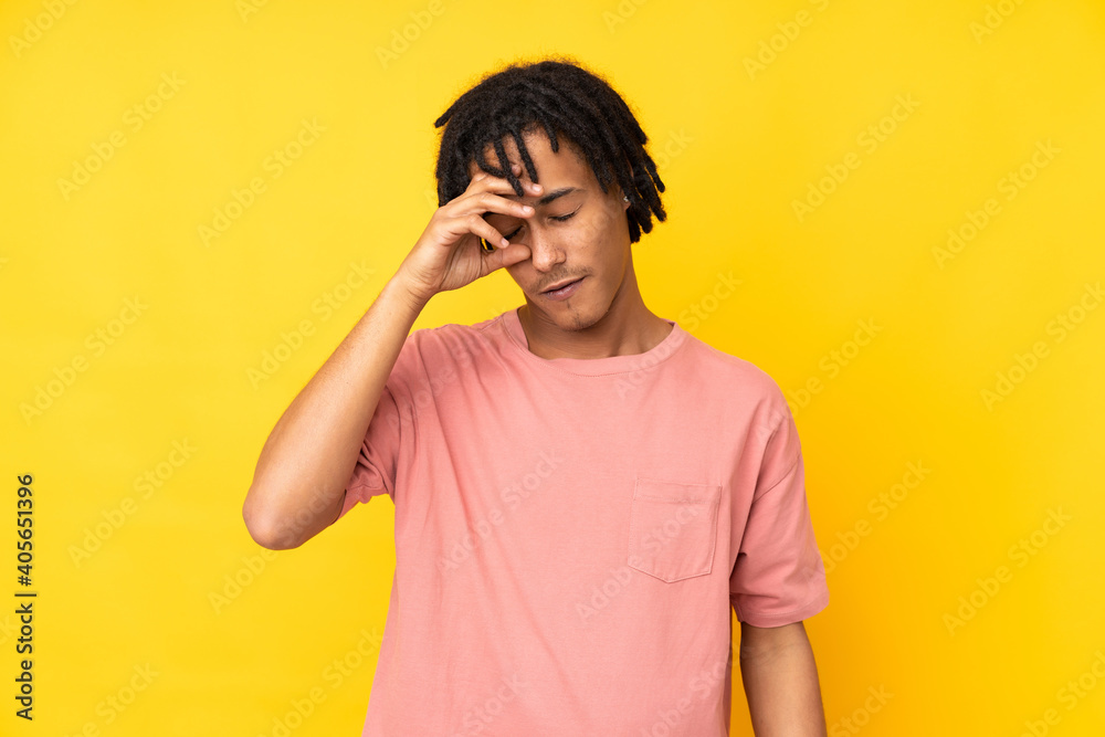 Young african american man isolated on yellow background with tired and sick expression Young african american man isolated on yellow background with tired and sick expression