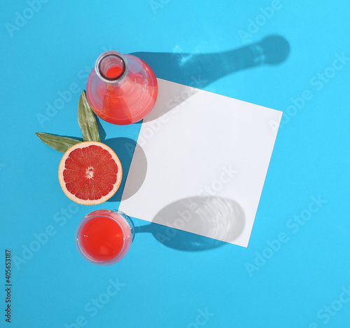 Jare of grapefruit juice with slices of grapefruit and paper card note. Minimal flat lay. photo