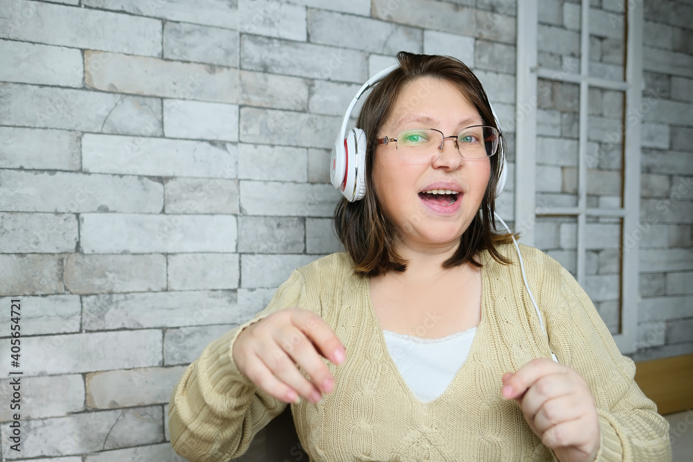 middle-aged woman with glasses and white headphones communicates from home via video call, gestures with her hands, concept of remote education, video conference, foreign language lesson middle-aged woman with glasses and white headphones communicates from home via video call, gestures with her hands, concept of remote education, video conference, foreign language lesson