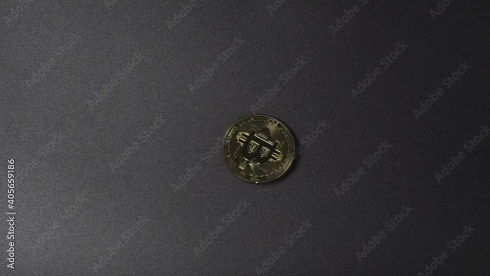 Close-Up of Gold Bitcoin drop and spin on black background floor Close-Up of Gold Bitcoin drop and spin on black background floor