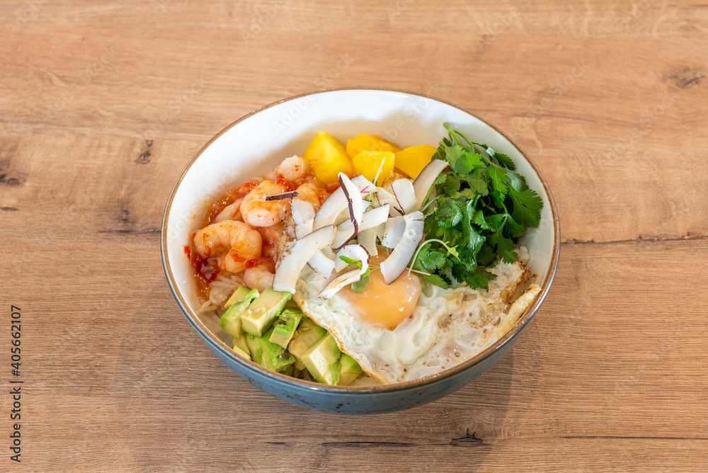 delicious bowl of prawns and mango on wooden table