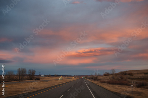 Beautiful sky at sunset dark blue and bright orange clouds over the highway © Liudmila