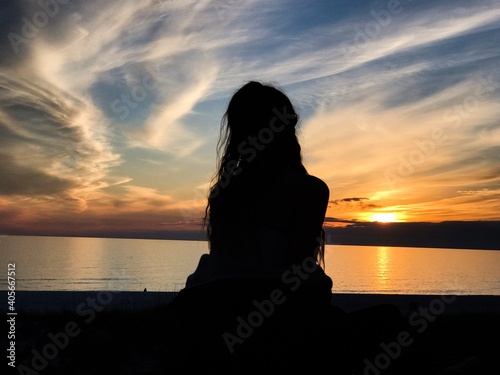 Silhouette of woman on beach during summer sunset