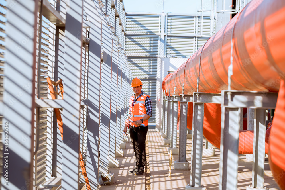 Engineer under checking the industry cooling tower air conditioner is water condenser cooling tower air chiller HVAC of large industrial building to control air system.