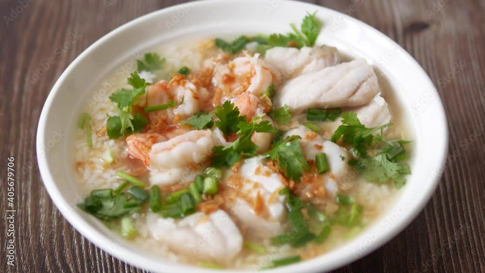 Slow motion zoom in shot boiled rice soup with fish and shrimp