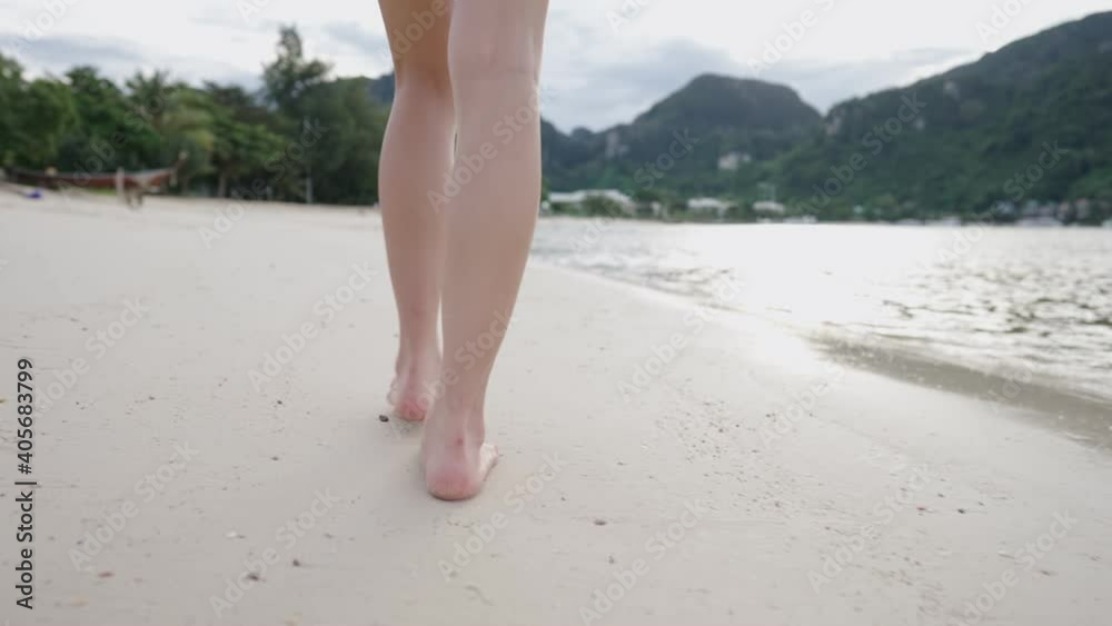 Low angle female take a walk along empty island sand beach shore, sun light reflection on the sea water, Freedom life escape from city, summer vacation slow motion, calm peaceful summer vacation Low angle female take a walk along empty island sand beach shore, sun light reflection on the sea water, Freedom life escape from city, summer vacation slow motion, calm peaceful summer vacation