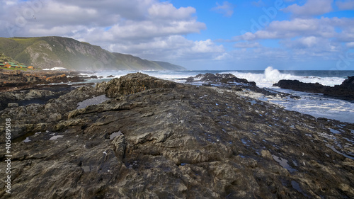 Rugged coastline with rocks, wild sea and mountains, rough coastal landscape in Tsitsikamma National Park Garden Route South Africa